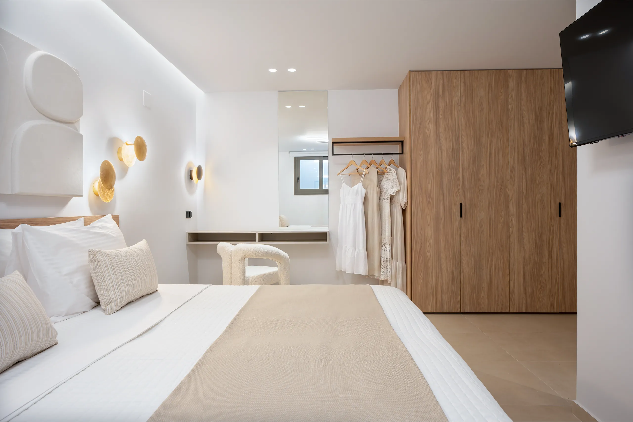A bright bedroom in Left Crete with timber wardrobes and a private bathroom