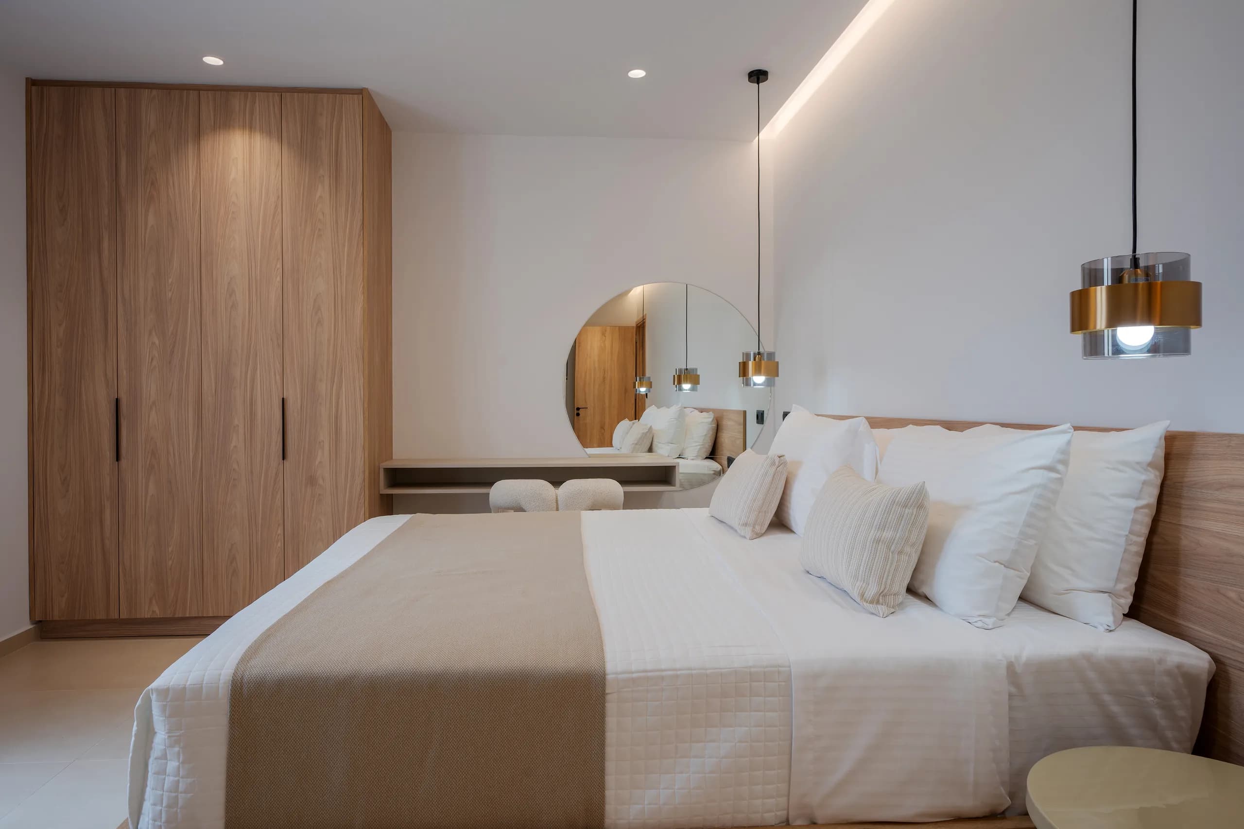 A Right Crete bedroom with a timber headboard, pendant lights and built-in wardrobe