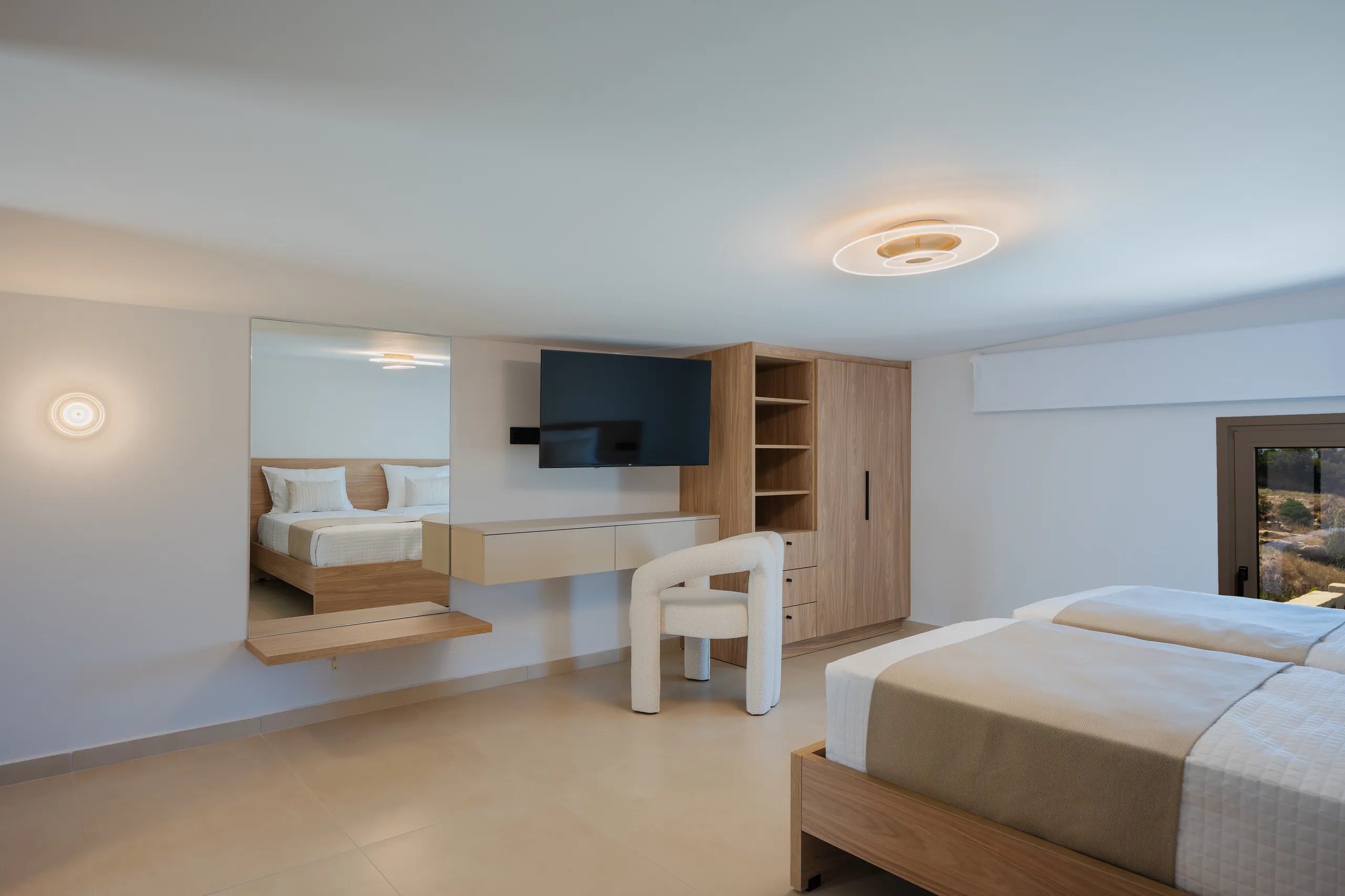 A bright Right Crete bedroom with a desk, mirror and timber storage