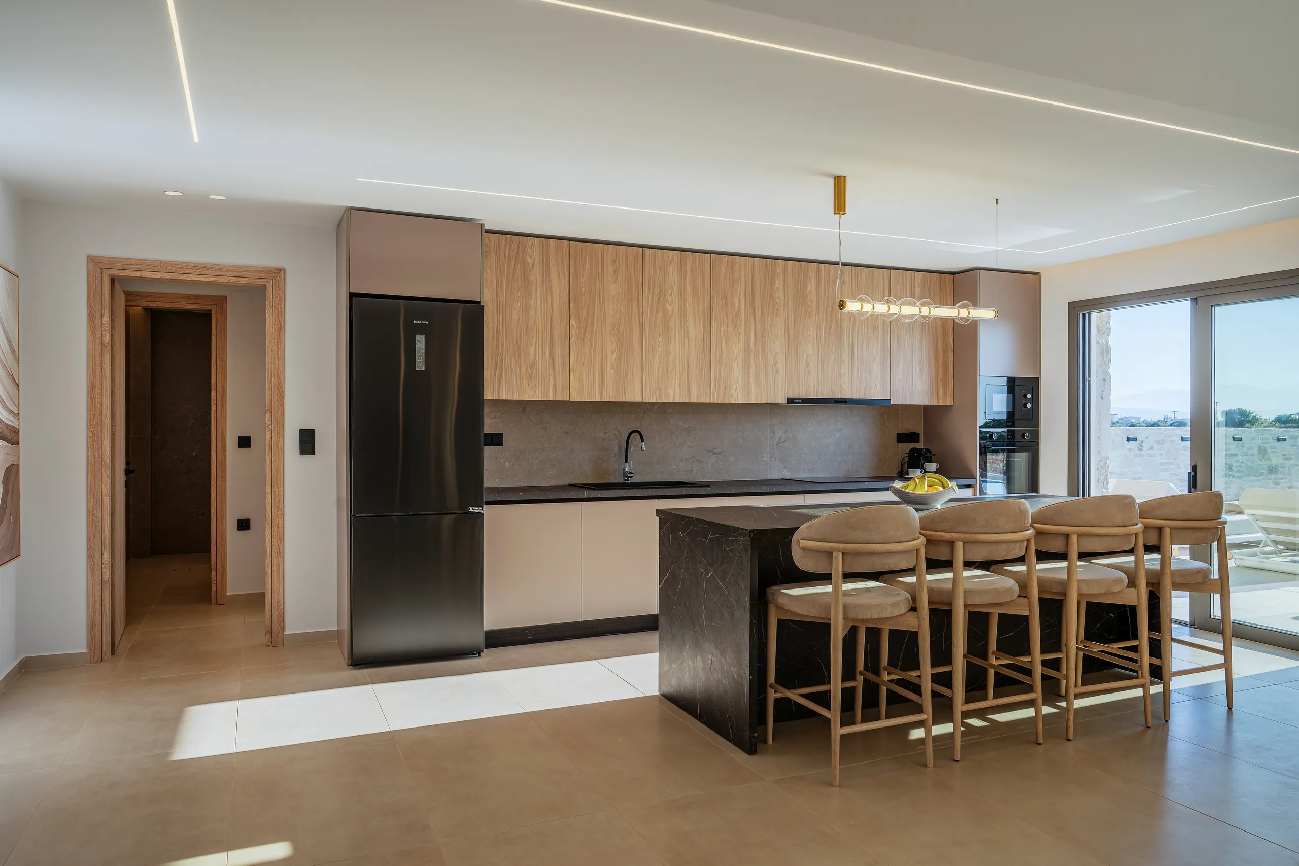 Right Crete's open kitchen and dining room with pale timber cabinetry
