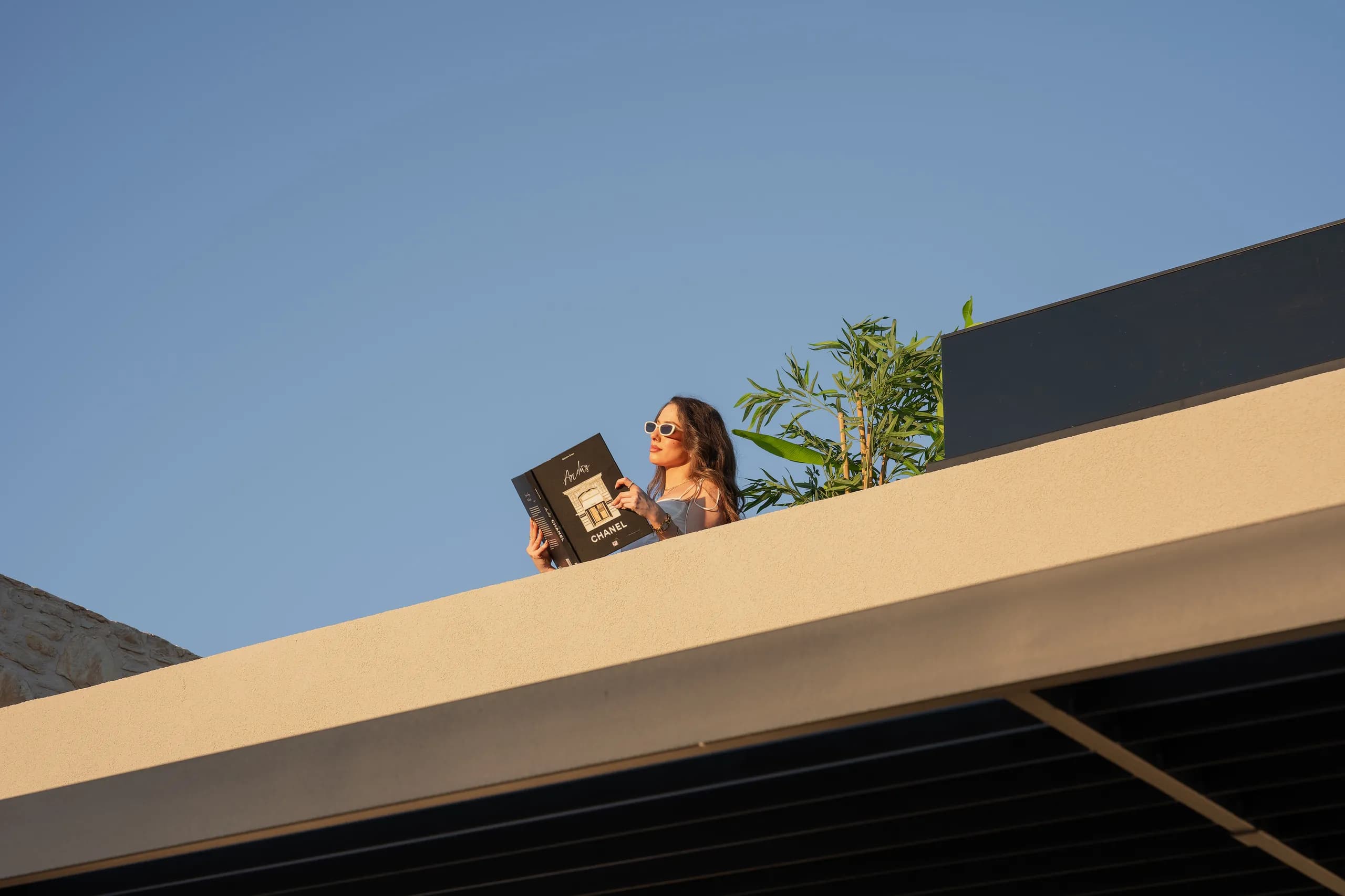 A guest reading on Left Crete's upper veranda beneath a clear blue sky